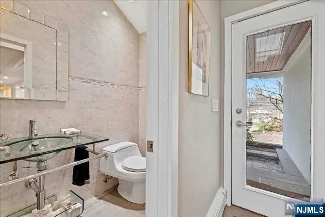 a bathroom with a granite countertop toilet a sink and a mirror