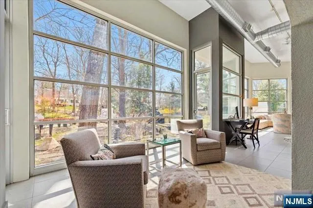 a living room with furniture tv and large windows