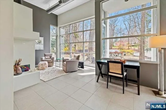 a living room with furniture a large window and a potted plant