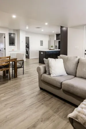 a living room with furniture and a wooden floor