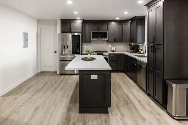 a kitchen with stainless steel appliances granite countertop wooden cabinets a refrigerator and a stove