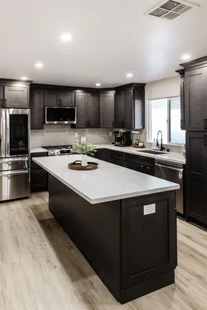 a kitchen with stainless steel appliances a sink a stove a microwave a refrigerator a counter top space and cabinets