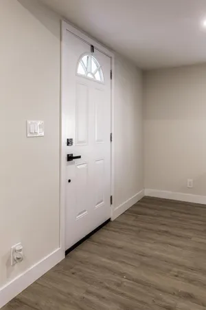 a view of an empty room with wooden floor