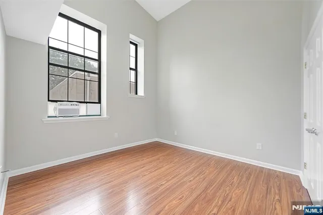 an empty room with windows and closet