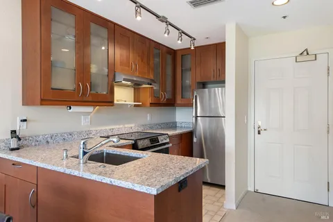 a kitchen with stainless steel appliances granite countertop a sink stove and refrigerator