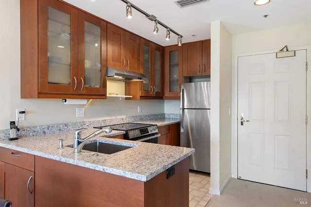 a kitchen with stainless steel appliances granite countertop a sink stove and refrigerator