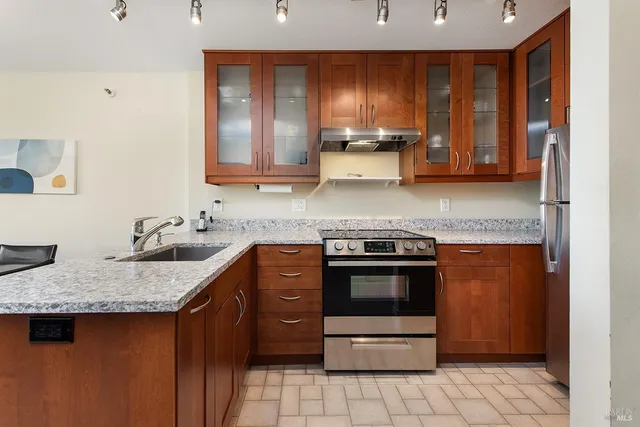 a kitchen with stainless steel appliances granite countertop a sink stove and cabinets