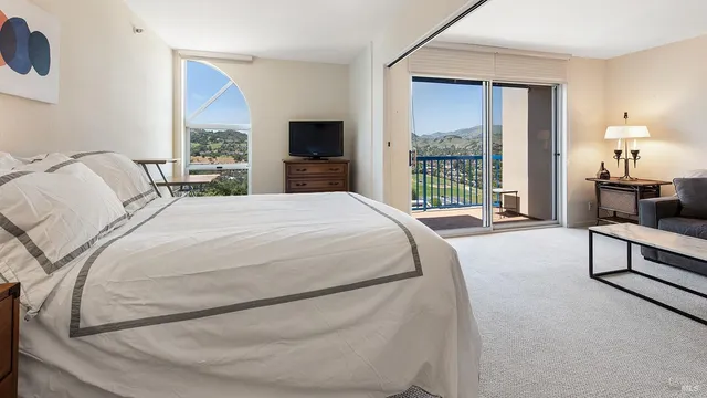 a bed sitting in a spacious bedroom next to a window