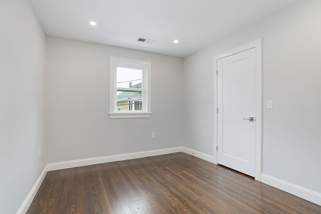 34 Brookvale Street Boston, MA 02124 - Photo 19 of 36 an empty room with wooden floor and windows