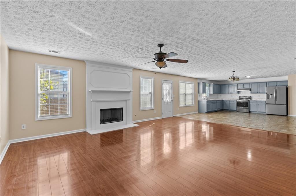 2760 Rusticwood Drive Southwest Snellville, GA 30078 - Photo 16 of 48 a view of a livingroom with a fireplace a ceiling fan and windows