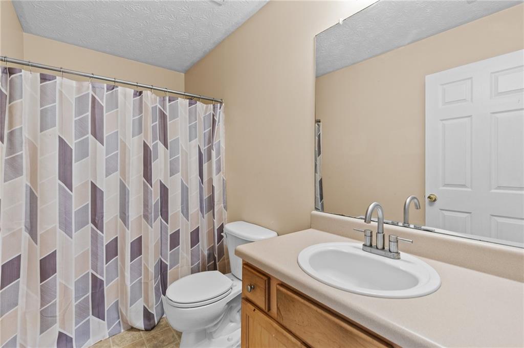2760 Rusticwood Drive Southwest Snellville, GA 30078 - Photo 34 of 48 a bathroom with a granite countertop sink a toilet and a mirror