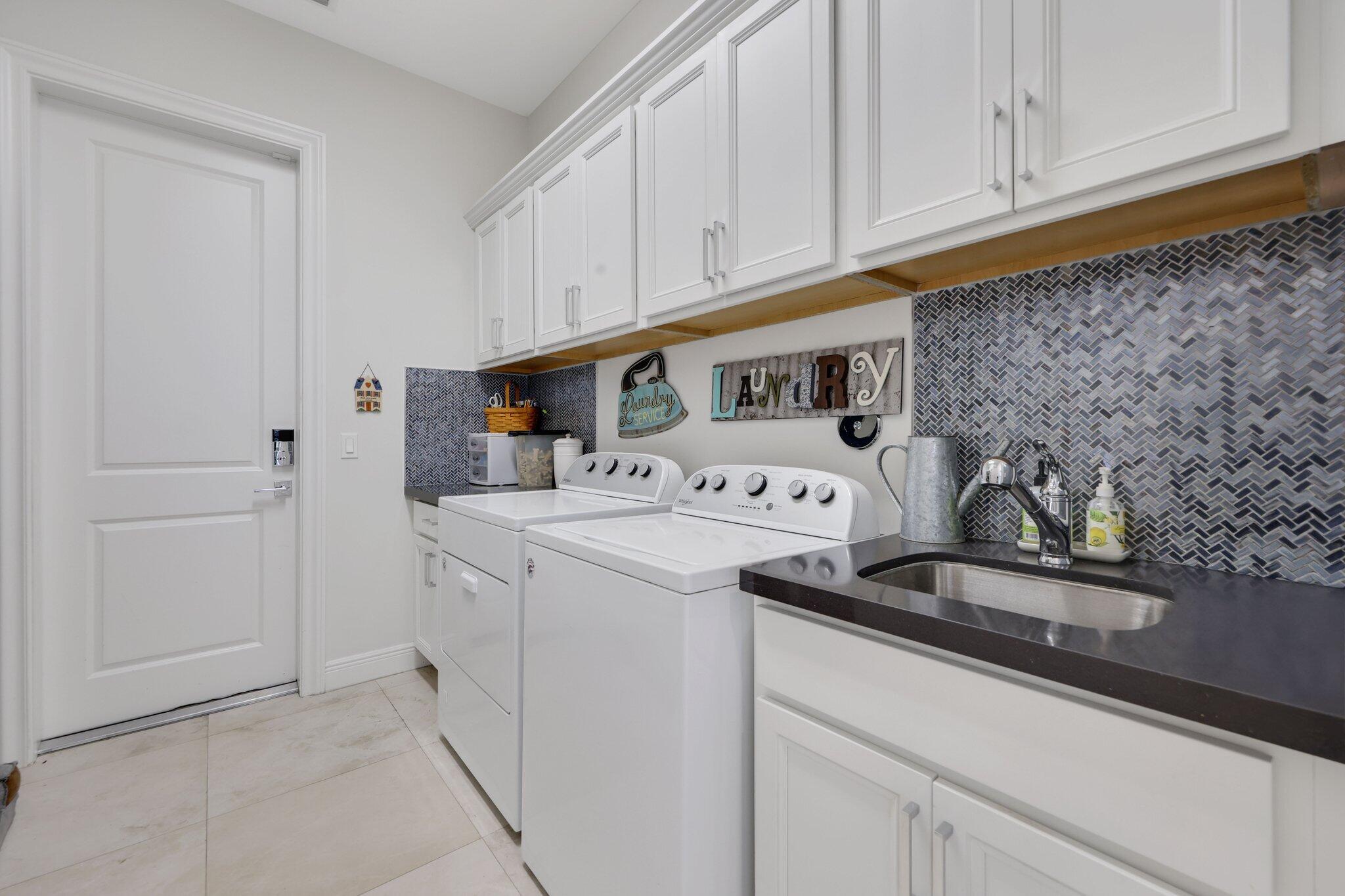 2530 Northwest 71st Street Boca Raton, FL 33496 - Photo 59 of 96 a utility room with stainless steel appliances granite countertop a sink and a white cabinets