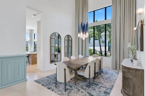a living room with furniture a floor to ceiling window and potted plants