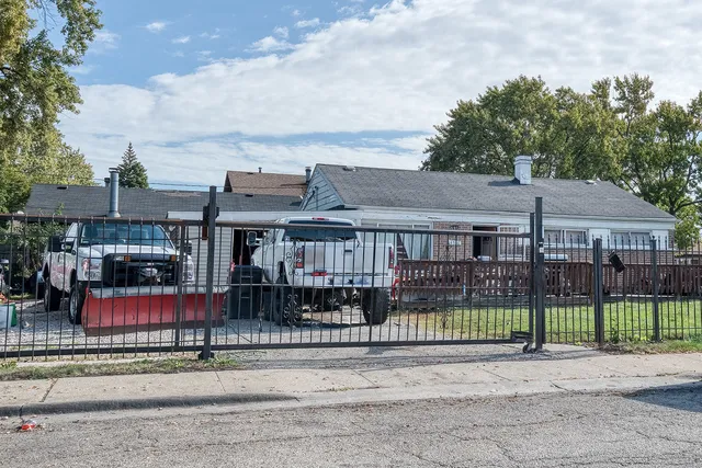 a front view of a house with a garden and trees