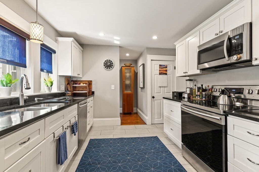 33 Porter Street, Unit 33 Woburn, MA 01801 - Photo 10 of 25 a kitchen with stainless steel appliances granite countertop a stove a sink and a microwave