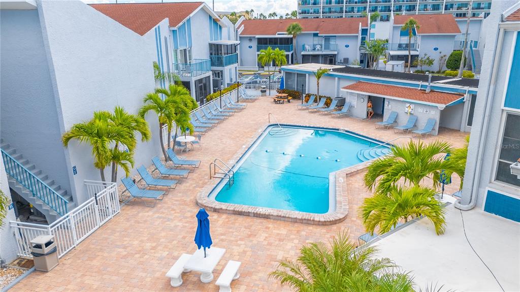 230 Medallion Boulevard, Unit E Madeira Beach, FL 33708 - Photo 24 of 35 a view of a swimming pool with outdoor seating