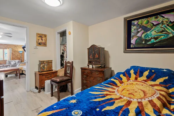 a bedroom with a bed table and a flat screen tv