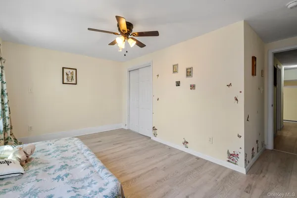 a view of a bedroom with a bed and wooden floor