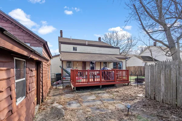 a view of a house with a wooden deck front of house