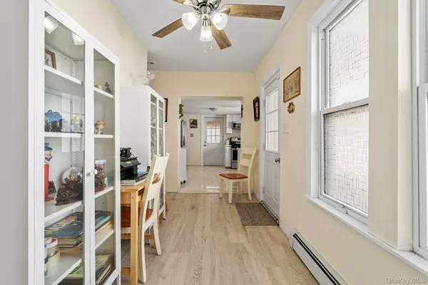 a view of a hallway with wooden floor and a living room