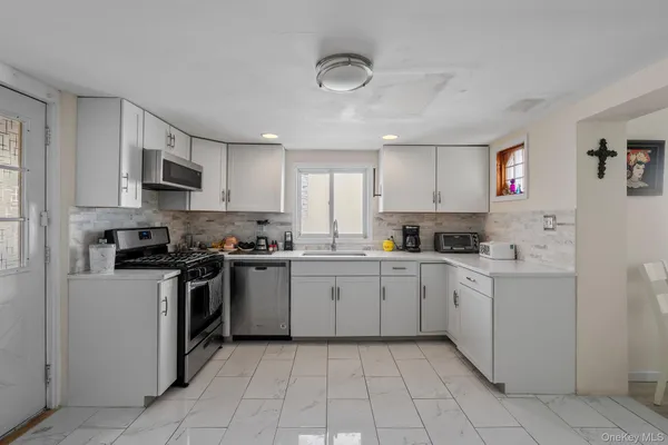 a kitchen with cabinets appliances a sink and a counter top space