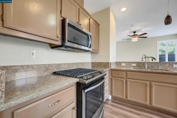 a kitchen with stainless steel appliances granite countertop a sink stove and microwave