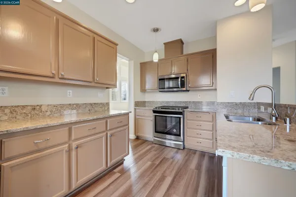 a kitchen with kitchen island granite countertop a sink stainless steel appliances and cabinets