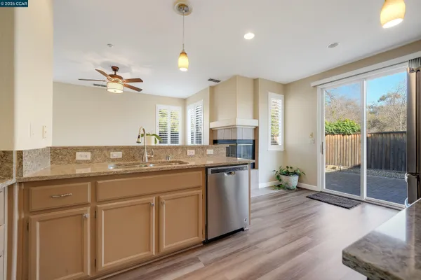 a kitchen with kitchen island granite countertop a sink cabinets and stainless steel appliances