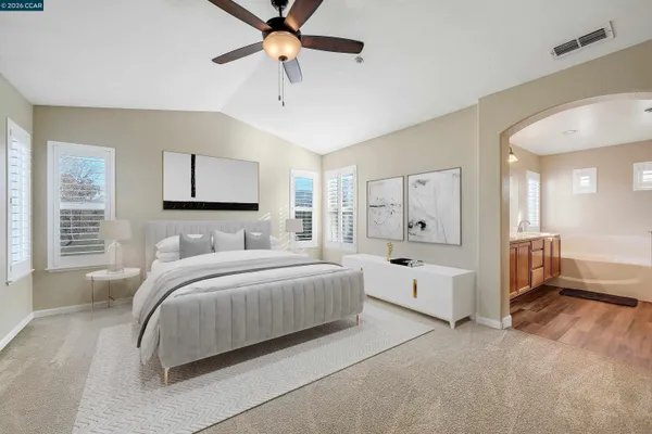 a room with a bed and ceiling fan