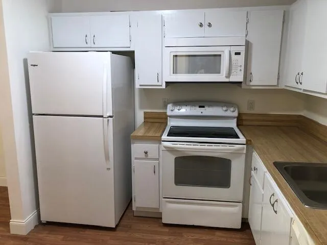 a kitchen with white cabinets and white appliances
