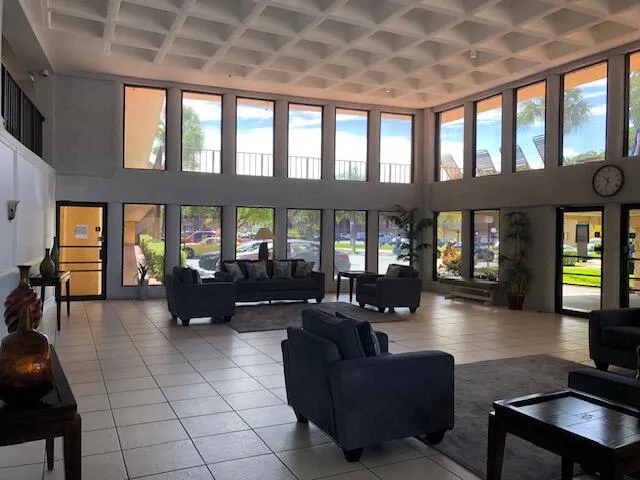 a living room with furniture fireplace and large windows