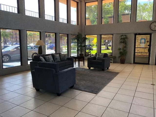 a living room with couches bookshelf and a stove with wooden floor