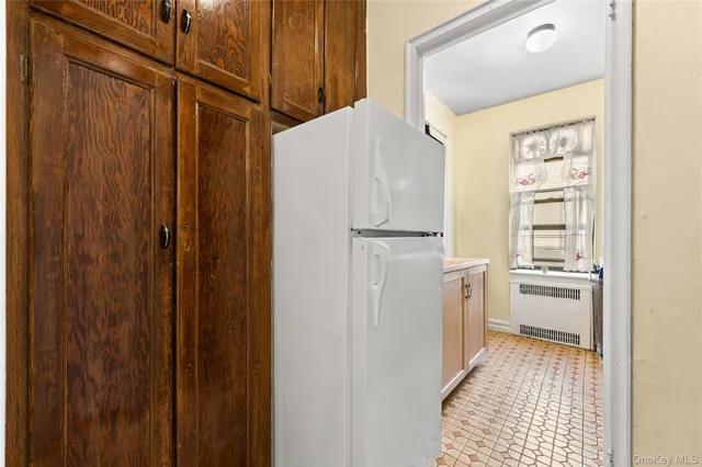 a kitchen with a refrigerator and white cabinets