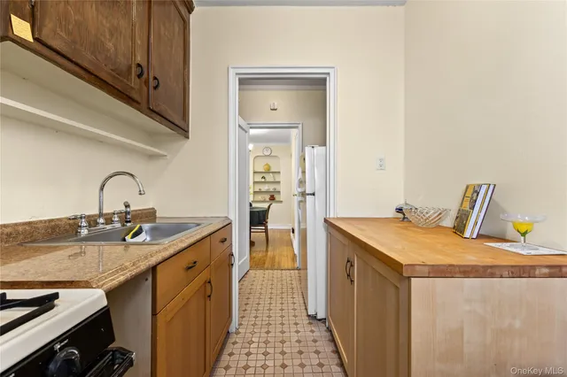 a kitchen with a sink a stove and wooden floor
