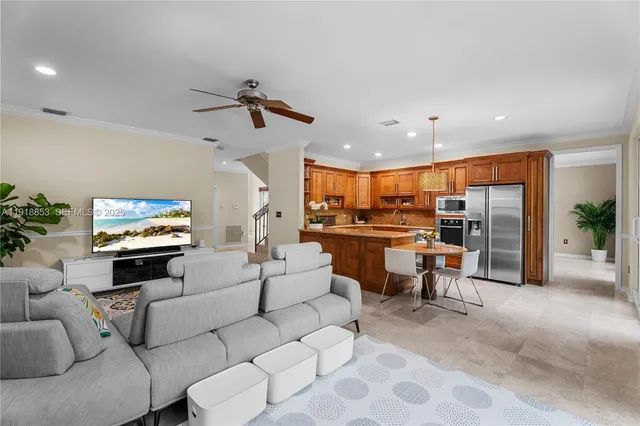 a living room with furniture kitchen view and a large window