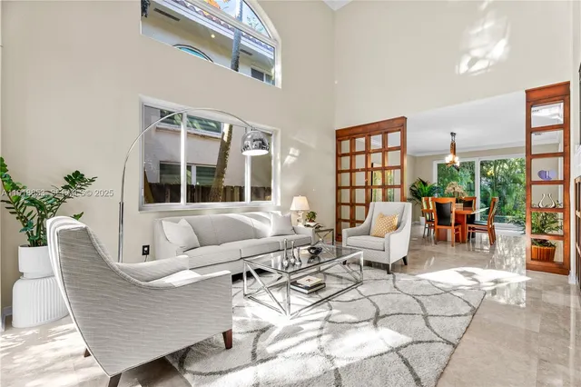 a living room with patio furniture and a large window