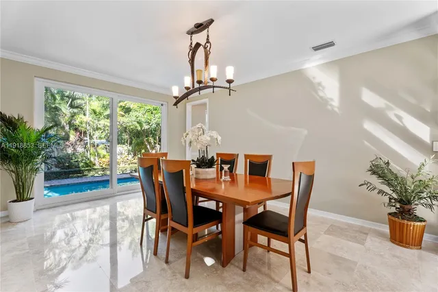 a dining room with furniture potted plants and wooden floor