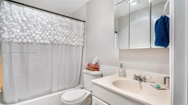 a bathroom with a sink a toilet and shower curtain