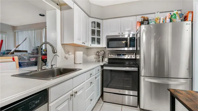 a kitchen with stainless steel appliances a refrigerator sink and microwave