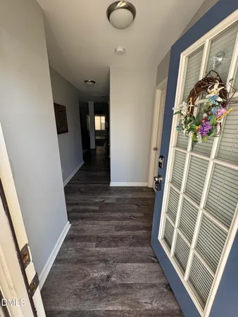 a view of a hallway with wooden floor and staircase