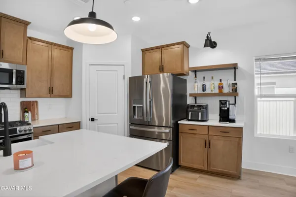 a kitchen with kitchen island a refrigerator stove and microwave