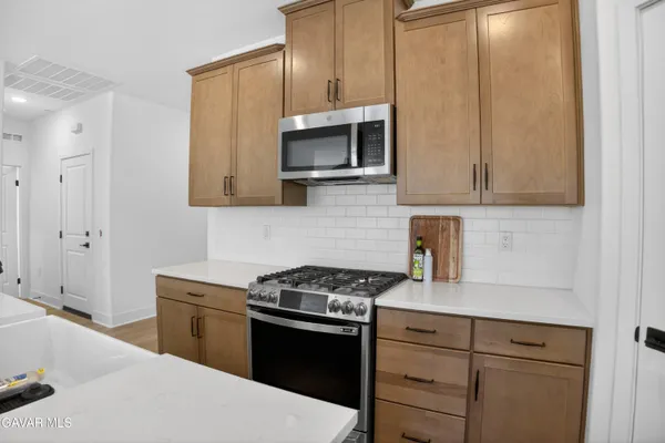 a kitchen with stainless steel appliances white cabinets and stove