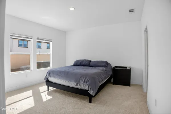 a large bed sitting in a bedroom next to a window