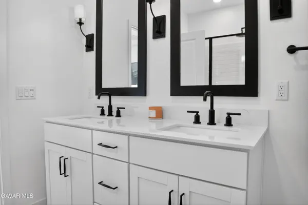 a bathroom with double sink and a mirror