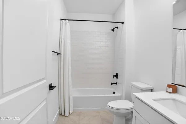 a bathroom with a granite countertop toilet a sink and a bathtub