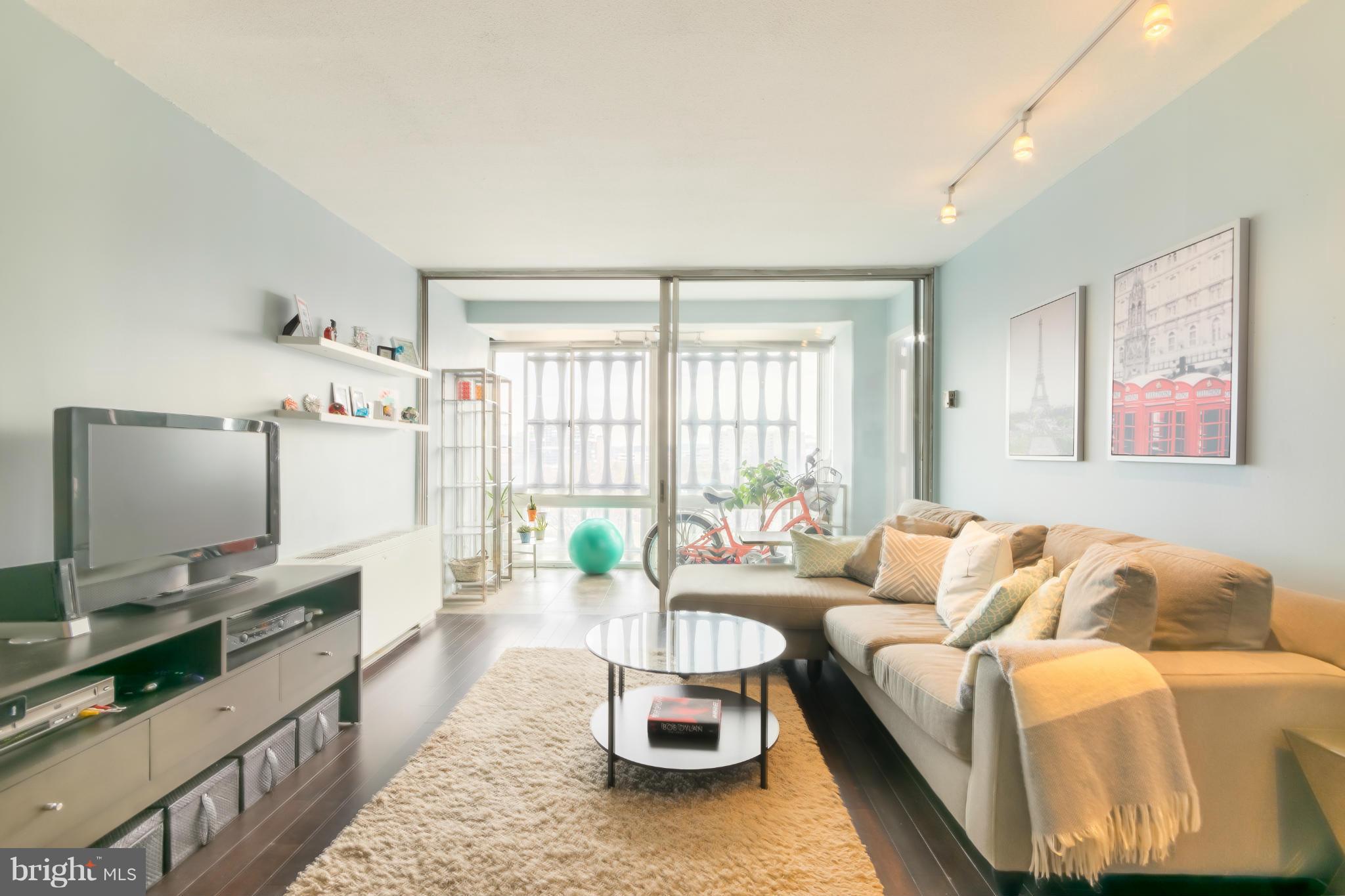 1301 Delaware Avenue Southwest, Unit N816 Washington, DC 20024 - Photo 3 of 20 a living room with furniture and a flat screen tv