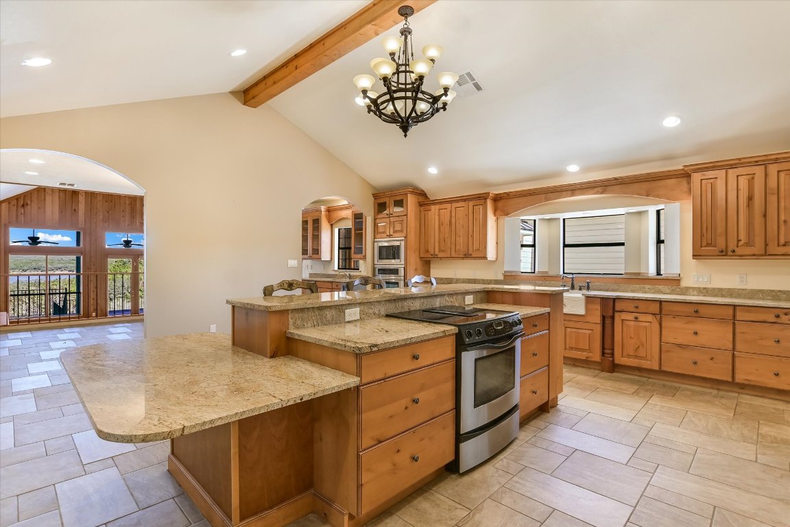 116 Courtside Way Spicewood, TX 78669 - Photo 12 of 40 a kitchen with stainless steel appliances granite countertop a sink and cabinets