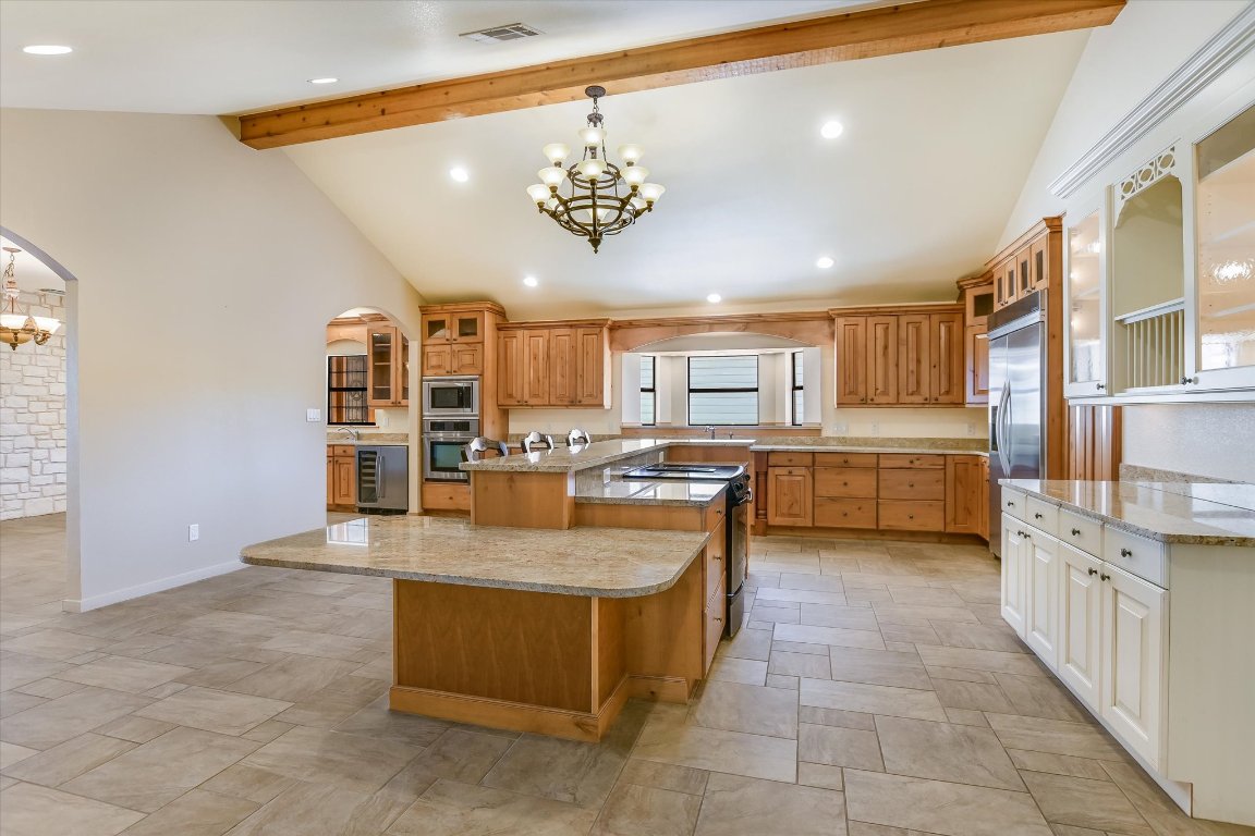 116 Courtside Way Spicewood, TX 78669 - Photo 14 of 40 a large kitchen with kitchen island a counter top stainless steel appliances and cabinets