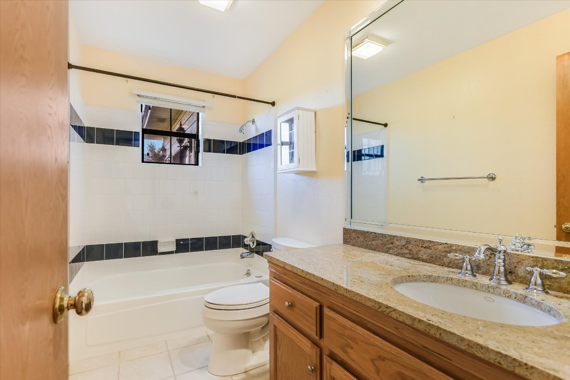 116 Courtside Way Spicewood, TX 78669 - Photo 21 of 40 a bathroom with a granite countertop sink toilet and shower