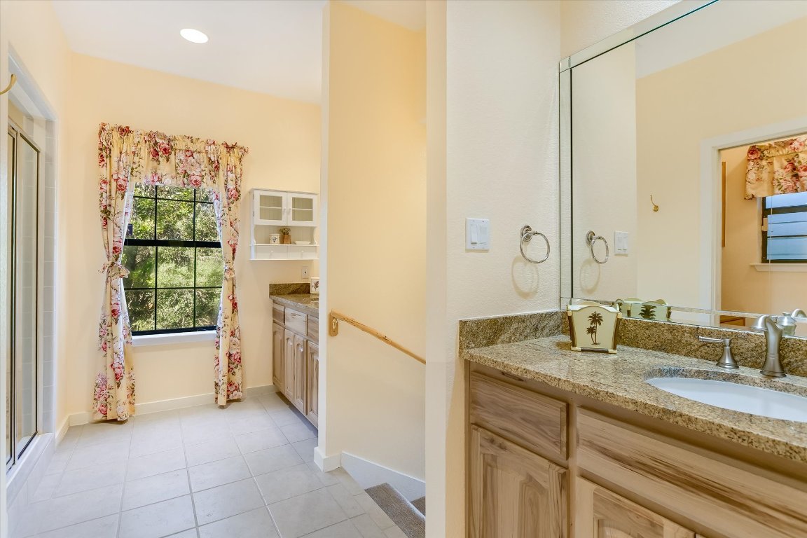 116 Courtside Way Spicewood, TX 78669 - Photo 23 of 40 a bathroom with a granite countertop sink and a mirror